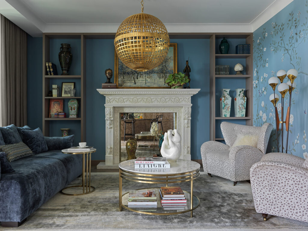 Гостиная. Мраморный камин из компании New Stone; в топку камина вставлено состаренное зеркало, мастерская Papà Carlo; вся встраиваемая мебель сделана на заказ в компании “Новый Интерьер”; обои, Fresq. на каминной полке картина Константина Горбатова “Зимний лес” 1912 года, фигурка “Собиратель ржавых гвоздиков” Наталии Лопусовой-Томской, скульп­тура Андрея Дроздова “Ожидание большого дракона”.