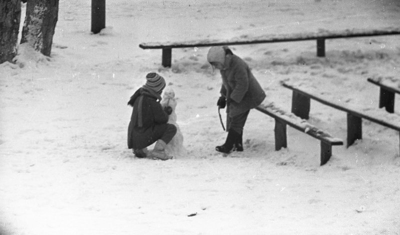 Девочки лепят снеговика во дворе, 1960-е годы. Автор фото - Ю. Садовников. Источник фото: russiainphoto.ru 