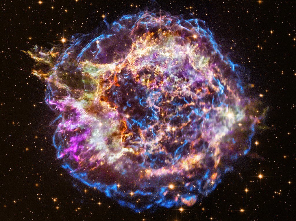 17 августа 2017 года гравитационные обсерватории Ligo и Virgo зафиксировали особые гравитационные волны прошедшие сквозь Землю. Гравитационные волны - это своеобразные искажения в пространстве и времени: представьте себе рябь на поверхности воды от брошенного в неё камня. От чего могут возникать подобные волны в космосе? Причин может быть множество, но за каждой из них стоит некое масштабное космическое явление. Спутник НАСА Fermi в то же время обнаружил достаточно сильные гамма лучи, происходящие из той же области.

Эти сигналы кардинально отличались от тех что кто либо видел ранее... Но именно этого и следовало ожидать от слияния двух нейтронных звёзд, вызвавших при своём столкновении страшный взрыв!
Это событие получило своё научное название: кило-нова, ну или по нормальному - взрыв сверхновой.

Давайте начнём сначала. Большинство звёзд медленно сгорают, или постепенно сбрасывают свою оболочку из газов в окружающее пространство, превращаясь в компактные объекты размером с планету, например, в белый карлик.

Очень редко жизнь звёзд заканчивается катастрофой.  Тогда при взрыве выделяется огромное количество энергии в виде нейтрино или электромагнитного излучения. И если это случается достаточно близко, то с Земли это можно наблюдать невооружённым взглядом - на небе внезапно появляется очень яркая звезда, которая постепенно, в течение нескольких дней, тускнеет.
В наши дни эти звёзды называют сверхновыми. Одну из самых ранее замеченных сверхновых наблюдали китайские и арабские астрономы ещё в 1054 году. От неё остался наиболее изученный объект - Крабовидная туманность, в средине которой находится бешеного вращающийся пульсар. В секунду он делает 33 оборота и излучает в различных диапазонах и излучает в различных диапазонах длинн волн.

Один из впечатляющих взрывов сверхновой произошел сравнительно недавно. Звезда, находящаяся на расстоянии 4,5 миллиардов световых лет от Земли, была определена как сверхновая, на основании данных телескопов панорамного обзора Pain Stars в феврале 2016 года. Усиление свечения звезды, как показали расчёты, началось ещё в декабре 2015 года, а максимум был отмечен в январе 2016.

Следует напомнить, что когда массивная звезда взрывается в виде сверхновой, на её месте остаётся сверхплотной сжавшееся ядро - нейтронная звезда. Поскольку масса у нейтронных звёзд в целом меньше чем у чёрных дыр, их слияния порождают более слабое излучение гравитационных волн, чем от слияния чёрных дыр. 

Можно сказать, что по этой причине наблюдение подобных явлений было не то чтобы сложным, оно было невозможным.

О чём же тогда речь в этой статье? О том случае, когда это стало возможным, благодаря близости сливающихся нейтронных звёзд к Земле.

Явление слияния двух нейтронных звёзд сопровождается взрывом в тысячи раз более ярким чем в случае типичной новой звезды. Поэтому его назвали кило-новой.

Плотность двух столкнувшихся нейтронных звёзд трудно представить, их радиус не превышает двух десятков километров, тогда как масса может быть соизмерима с массой Солнца, что приводит к приблизительному параметру плотности, равному примерно 10в 17 степени киллограммов на кубический метр. При этом они почти полностью состоят из нейтронов, почти как чёрные дыры, но не совсем.
По иронии судьбы такое масштабное по астрономическим меркам событие протекает крайне быстро, его очень трудно заметить, поэтому учёные никогда ранее не фиксировали гравитационные искажения таких слияний. Известно, что учёные провели коллосальную работу по локализации этого фантастического сигнала. По факту можно сказать, что все самые высокотехнологичные астрономические приборы Земли в тот момент были обращены на изучение этого события. И вскоре учёные обнаружили, что данный сигнал происходил из созвездия Гидра, в галлактике, находящейся в 130 миллионах световых лет от Солнца.

Впервые этот взрыв был обнаружен со станции в Чили, но по мере обращения Земли, в следующий раз этот взрыв можно было наблюдать уже над Австралией.
Нужно понимать, что такой взрыв - не секундное событие, оно растянуто во времени.
...Восемь часов спустя его наблюдали над Южной Африкой... И так на протяжении двадцати четырёх часов учёные могли наблюдать этот взрыв три раза.

Кстати, первое зафиксированное наблюдение кило-ново произошло гораздо ранее - в 2008 году: по кратковременным всплескам гамма-излучения - интенсивным вспышкам гамма-излучения продолжительностью менее двух секунд, учёные сумели сделать предположение, окончательно подтвердившееся именно в 2017 году. 

Астрономы давно пришли к выводу, что коллапс двух нейтронных звёзд приводит к возникновению тяжёлых элементов, таких как золото. Получается, что золото в вашем украшении могло быть когда то создано благодаря подобному взрыву...

Согласитесь, вот это действительно крутая алхимия!

Учёные давно задавались вопросом, как в нашей вселенной создаются элементы, более тяжёлые чем железо?
Известно, что элементы, более лёгкие чем железо, создаются посредством звёздного нуклео-синтеза в ядрах звёзд.
Но теперь у нас есть свидетельство, что кило-нова так же являются космическими литейными цехами, где самые тяжёлые элементы образуются, и затем рассыпаются по вселенной. При этом запускается процесс синтеза тяжёлых элементов основанный на захвате ядрами нейтронов, так называемый R-процесс, в результате которого во вселенной произошло множество различных тяжёлых элементов, таких как золото, платина, или уран.

По предположениям учёных, при очередном взрыве кило-новой может произойти огромное количество золота - до десяти масс Луны.

Теперь же учёные смогли наблюдать не только рождение кило-новой, но и продукты её работы: спектры, полученные при помощи телескопов Хаббла и VLT, показали наличие цезия, теллура, золота, платины, и других тяжёлых элементов, образованных при слиянии нейтронных звёзд...

Возможно, благодаря этим исследованиям учёные смогут проанализировать условия, попросту, невозможные на Земле. И даже раскрыть секреты происхождения некоторых тяжёлых металлов.

До этого момента, всё что мы знаем о вселенной, мы получали с помощью света, и прошло почти 500 лет с той поры когда был изобретён телескоп - наш единственный на долгие столетия способ взаимодействовать с бескрайним космосом. ....И тут выходят в действие гравитационные детекторы - абсолютно другой способ изучения этих пространств.

Зафиксированный в 2017 году взрыв - это первый в истории синтез двух способов изучения космических явлений, с помощью света, и с помощью гравитационных волн....

А теперь задумайтесь о перспективах. Человечество постоянно открывает что то новое, и изобретает новые способы изучения мира, которые ещё больше раскрывают рамки возможностей познания. А возможно и применения полученных знаний.

Такова часть сущности человека, которая мне больше всего нравится - мы постоянно изучаем что то новое, наблюдаем, учимся, на основе этого открываем новые способы и методы, и таким образом проводим эволюцию, развитие своего вида.

И этим событием я хотел бы упомянуть не о космосе в частности, и не о гордости тех кто придумали и построили новую технологию. А о самом способе.
Столь интересное, и полезное, открытие, не было сделано одним человеком, и даже не кучкой людей... Нет, я хочу привести пример, что результат этого исследования стал возможен лишь благодаря слаженному взаимодействию разных специалистов, механизмов, стран, и организаций со всего мира.

Начиная с тех, кто по крупицам всё это финансировали, и тех кто это создали, и тех кто проводили расчёты, предположения, и вычисления, и в конце концов, тех кто работали непосредственно над этим вопросом, взаимодействуя с коллегами, советуясь и корректируя слаженную работу.

Люди коммуницируют между собой, а не грызутся за собственное "Я" и попытки урвать кусок побольше!

Представьте перспективы именно в таком ключе - если люди во всех сферах своей деятельности вдруг одумаются, перестанут пытаться самостоятельно постичь непостижимое, и вдруг обнаружится, что общими усилиями всё возможно.

Возможно, осмыслив перспективы, и начав изучать эти темы, применять их, мы уже сейчас начнём приближать развитие нашего вида, и как знать... Возможно, уже наши потомки сами научатся синтезировать и создавать космические тела, звёзды, и чёрные дыры, делать из них космические реакторы, и добывать из них как энергию, так и получать с их помощью всё необходимое для жизни и для прогресса.

Ведь точно так же когда то человек ждал молнию, чтобы зажечь огонь... А другие смотрели на вулкан, и наблюдали как из него вытекает раскалённый камень и как плавится металл... А потом были изобретены, фактически можно сказать что синтезированны, их аналоги - огонь, и плавильные печи литейных цехов...


А вы сами хотя бы раз видели явление сверхновой в небе? Наблюдали ли вы когда звезда вдруг ярко засияла в небе, и затем медленно угасала?





