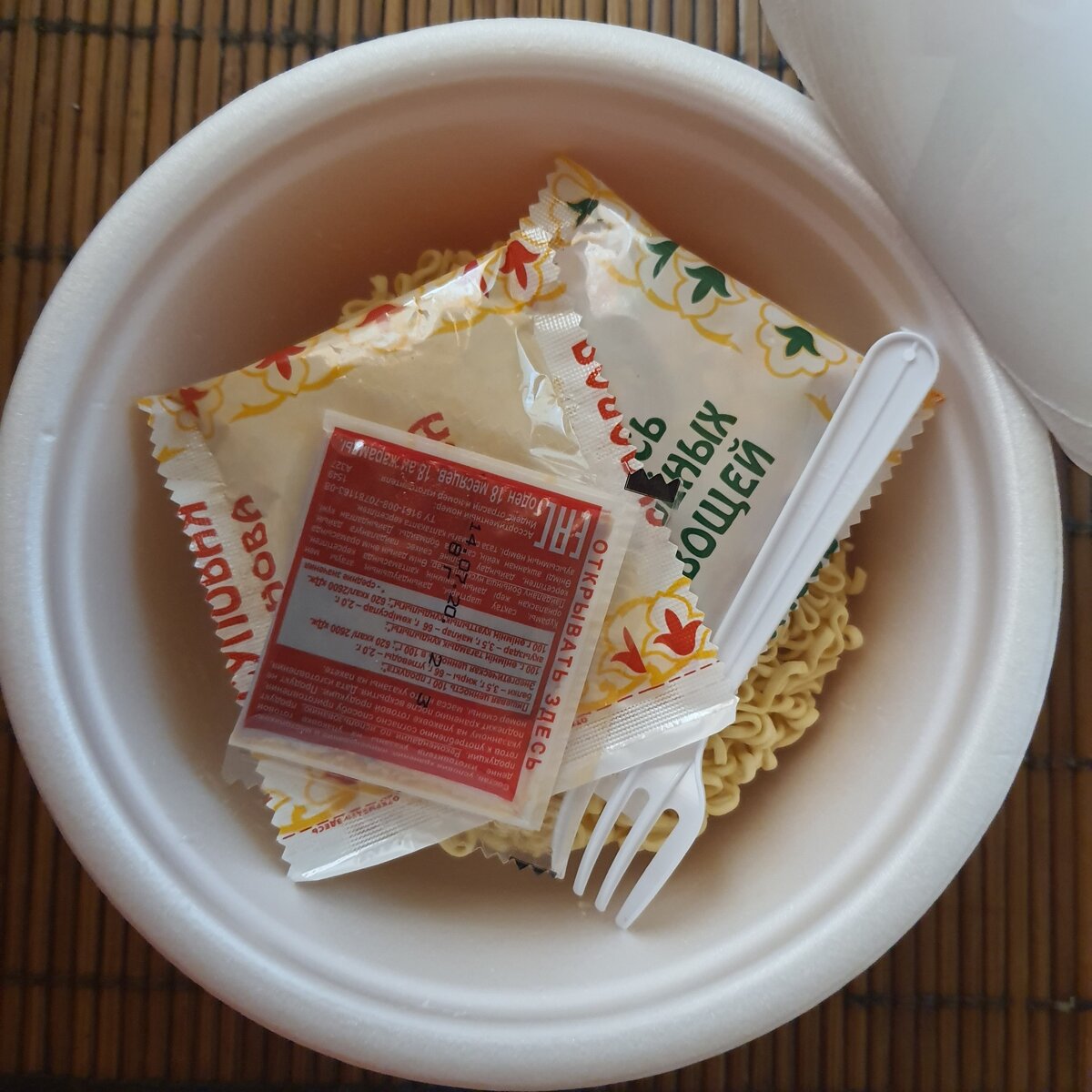 Стандартное содержимое любой лапши. Сушеные овощи, суповая основа, соус и ужасная вилка. Собственное фото автора канала. 