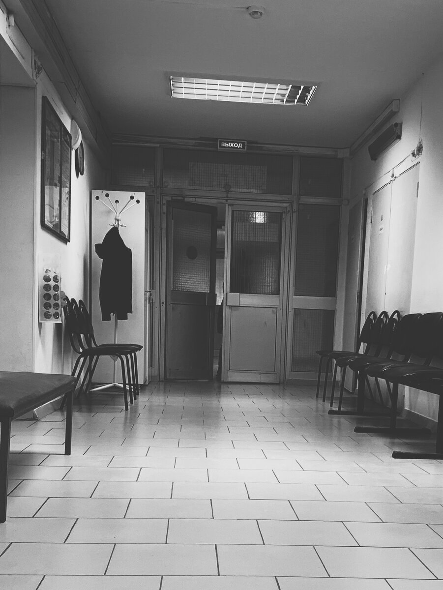 На фото: уборщица, домывшая пол, выходит из коридора, где делают вакцинацию от ковида. 