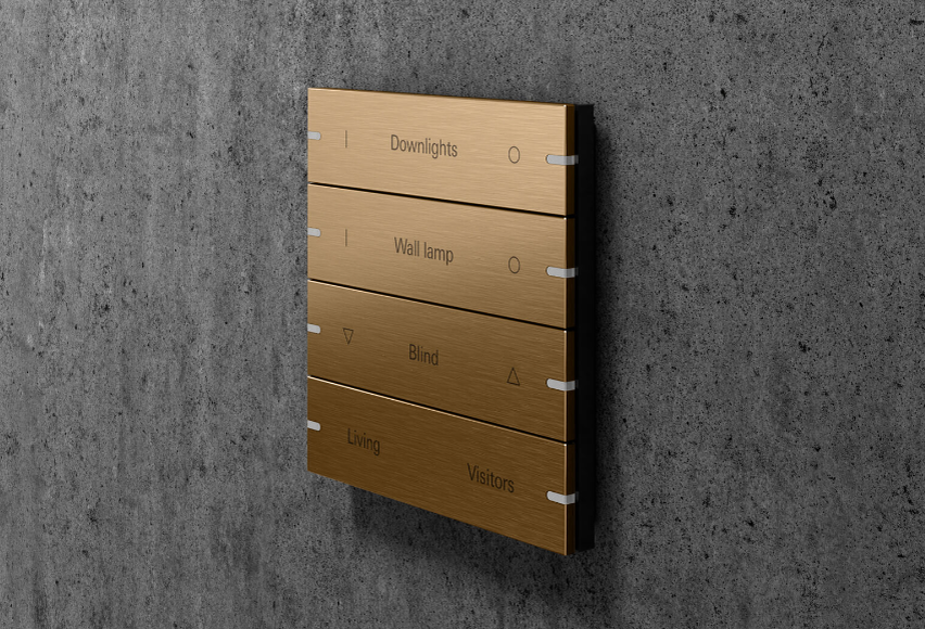 Умный выключатель Gira из бронзы (PVD) прекрасно дополняет теплый свет открытого огня. Источник: Гира