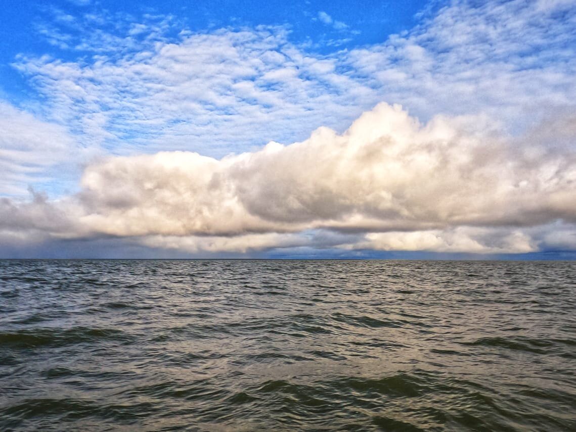 В какой-то момент вышло солнце и стало видно, как низко висят тучи над водой. Можно дотронуться рукой