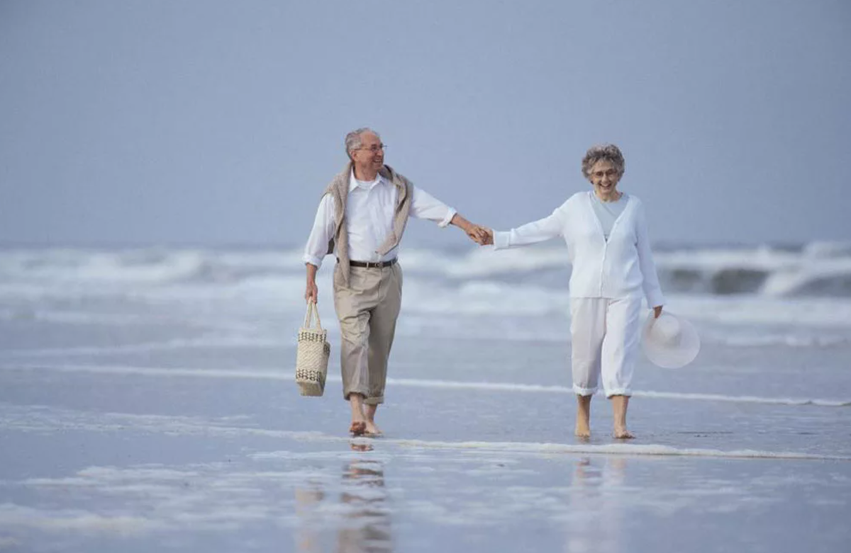 Прекрасной долгой жизни. Достойная старость. Пожилая пара гуляет по пляжу. Дружба и Возраст. Счастливые пенсионеры на море.