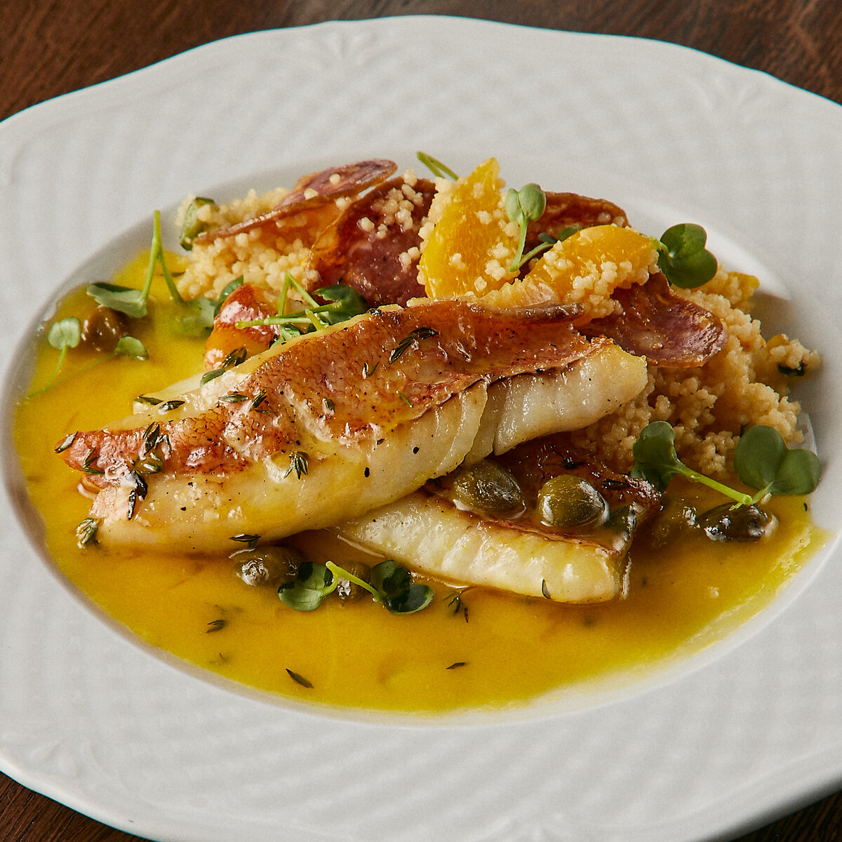 Морской окунь с чоризо и кускусом с апельсиновым соусом