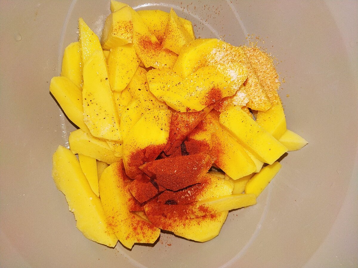 Нарезаем картофель произвольно, затем добавляем специи :паприка, соль, перец чёрный, чеснок,чили, оливковое масло