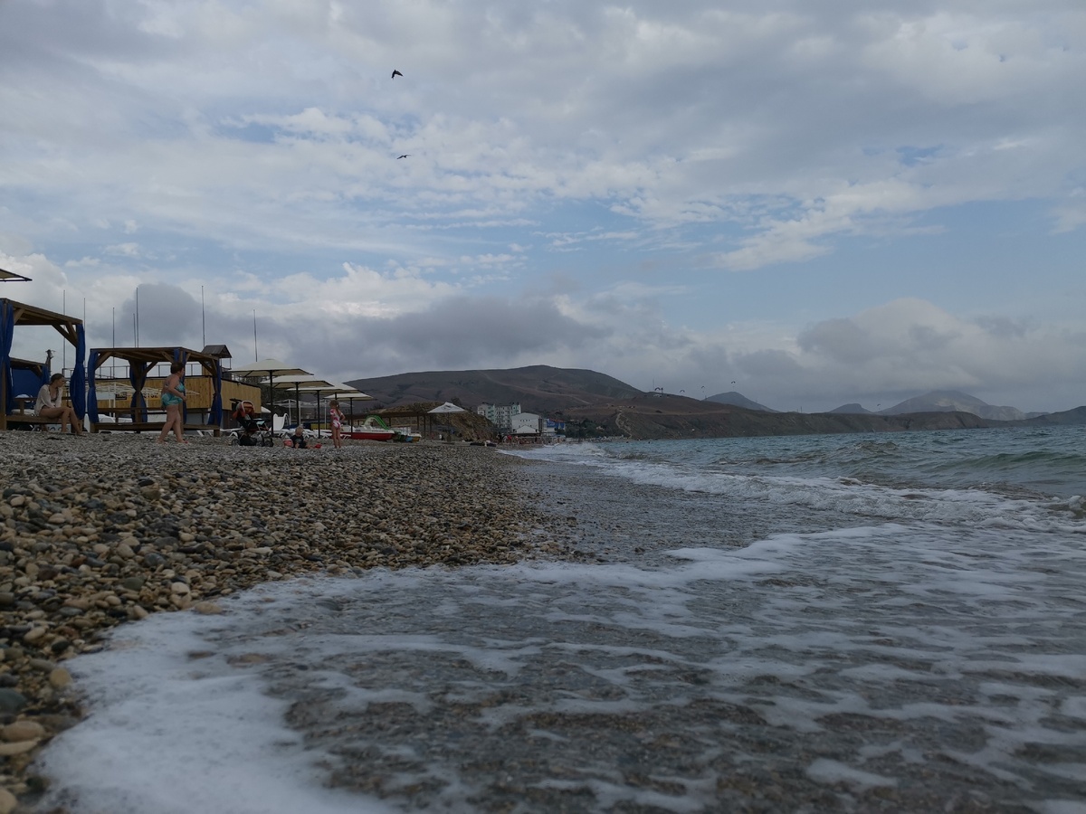 Каменистый пляж, ветер, волны. Солнца нет. Людей почти нет. Вода +23, воздух +21. Летом здесь горячей кукурузе упасть негде.
