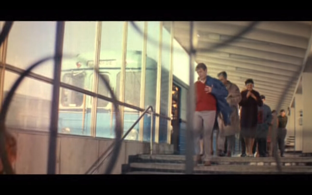 Главный герой в красном поло спускается с платформы станции