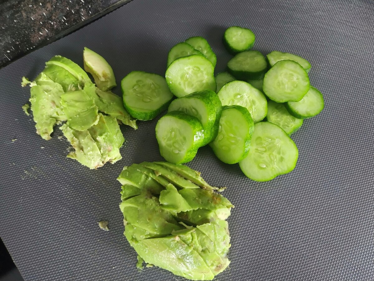 Огурцы нарезать колечками. Авокадо очистить от кожуры и нарезать тонкими слайсами (слайсы можно нарезать поменьше). Выложить к рукколе.