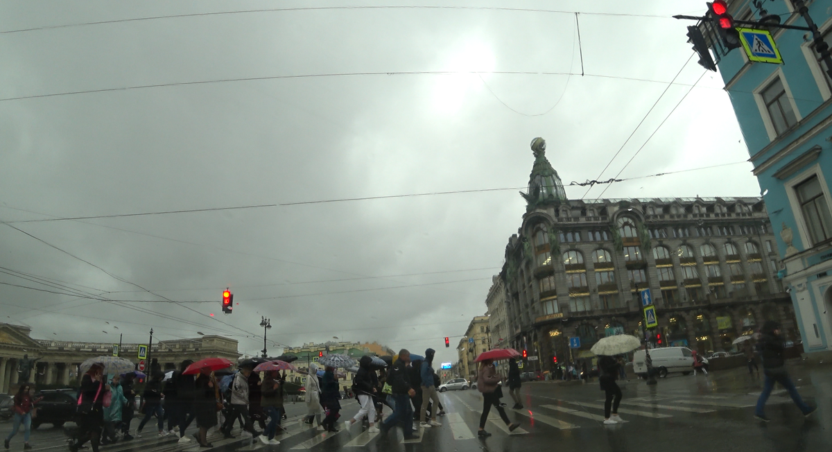 Толпы людей переходят улицу у Казанского собора и метро Невский проспект.