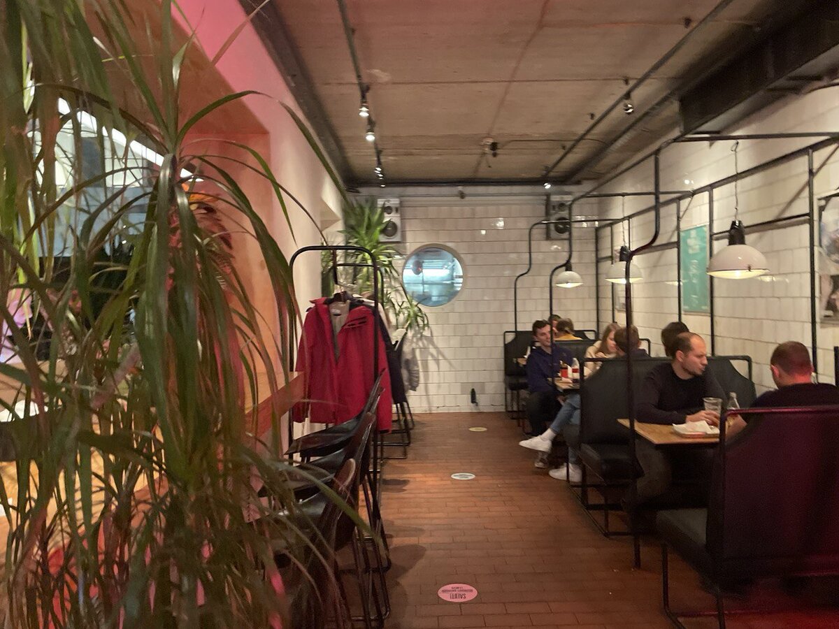 Старое помещение, раньше здесь помещалось всё, включая выдачу. Похоже на маршрутку, только с афишами и наклейками на кафельных стенах. Уют всегда давало обилие растений - они буквально спасали атмосферу, делали кафе уютным, а не казенным. 