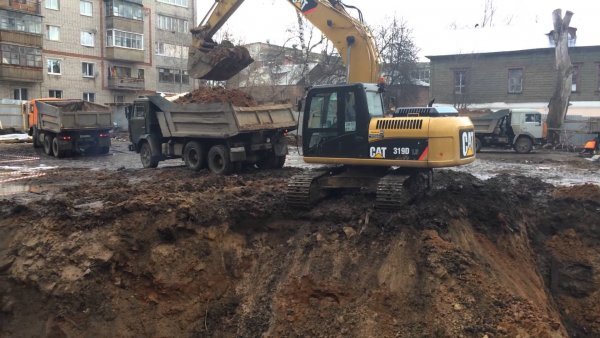 Выемка земли экскаватором и погрузка ее в самосвалы