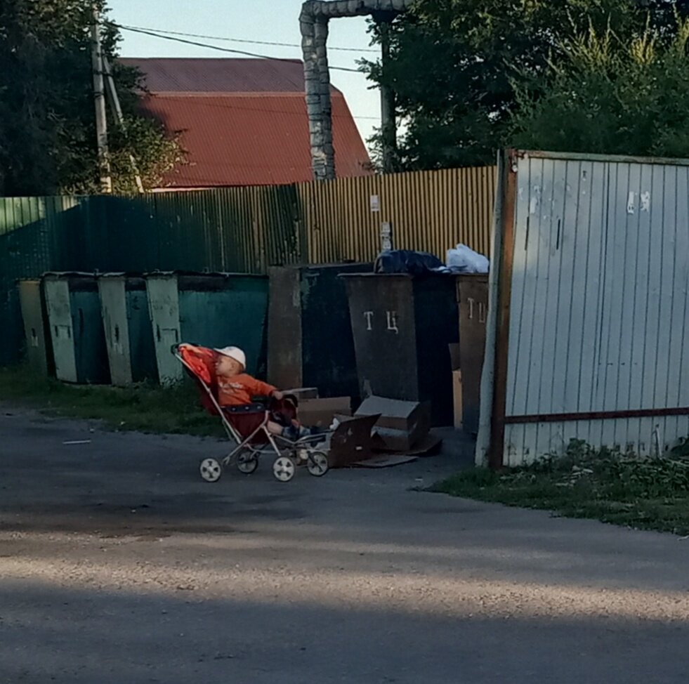 малыш около мусорных бочков