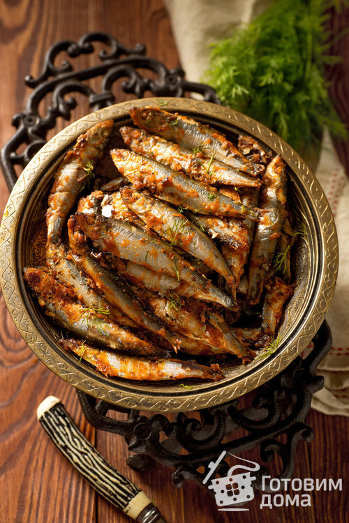 Килька, жаренная в духовке - невероятно вкусный, простой, дешевый и быстрый рецепт, который я когда либо встречала среди рыбных блюд! Это просто экспресс-рецепт, так как готовится буквально 15-20 минут! Друзья, я от него просто в восторге! Готовлю его уже давно, но только что посетила мысль поделиться этим рецептом  с вами :) 
Жареная килька настолько вкусна, что разлетается, как семечки, как в горячем, так и в холодном виде!
Рыбка настолько хороша и универсальна, что ее можно готовить по разным поводам: она может быть как закуской, так и вторым блюдом, в любом случае, все дегустаторы останутся довольными!
Но есть несколько тонкостей и секретиков, благодаря которым вы обязательно занесете блюдо в разряд самых любимых и включите его в ваше повседневное меню. 
Итак, главное, на что нужно обратить внимание - это то, что килька должна быть хорошего качества, не иметь никаких посторонних неприятных запахов, т.е. запах должен быть рыбный, свежий. Если есть подозрения по внешнему виду или по запаху - лучше не берите такую рыбу. Я покупаю кильку на рынке или в супермаркете, но в супермаркете гораздо реже можно найти рыбу хорошего качества, чаще всего она перемороженная. В общем, думаю, у вас есть хорошие проверенные рыбные места ;)
И второе, не менее важное условие вкусной рыбки - это время и температура запекания. Т.к. килька - рыбка мелкая, соответственно, готовится она очень быстро. Итак, запекаем кильку при 200 градусах Цельсия 12-15 минут, но не более! Будете держать ее в духовке полчаса, даже если при 180 градусах - получите непонятный сухой продукт. А если учтете мои советы и рекомендации, то порадуете ваших близких вкуснейшей килькой, жаренной в духовке. И еще хочу подчеркнуть, что рыбка при такой температуре получается больше похожей на жареную, чем на запеченную и поэтому очень и очень вкусной, и при том не вредным, а даже полезным продуктом!
Кроме кильки, можно запекать и другую мелкую рыбку, но главное здесь, как я уже говорила, чтобы рыба была свежей, без посторонних запахов.
Ну что, попробуем приготовить?! :)
