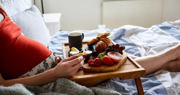 Беременная женщина есть в постели