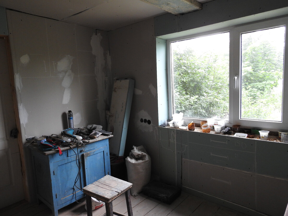 Мои художества на гипсокартоне: на стене слева шкафчик и стеллаж, под окном мойка 
и тумба с выдвижными ящиками.