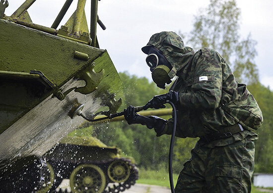 Военнослужащий войск РХБЗ ВС России занят очень увлекательным процессом дегазации бронетехники