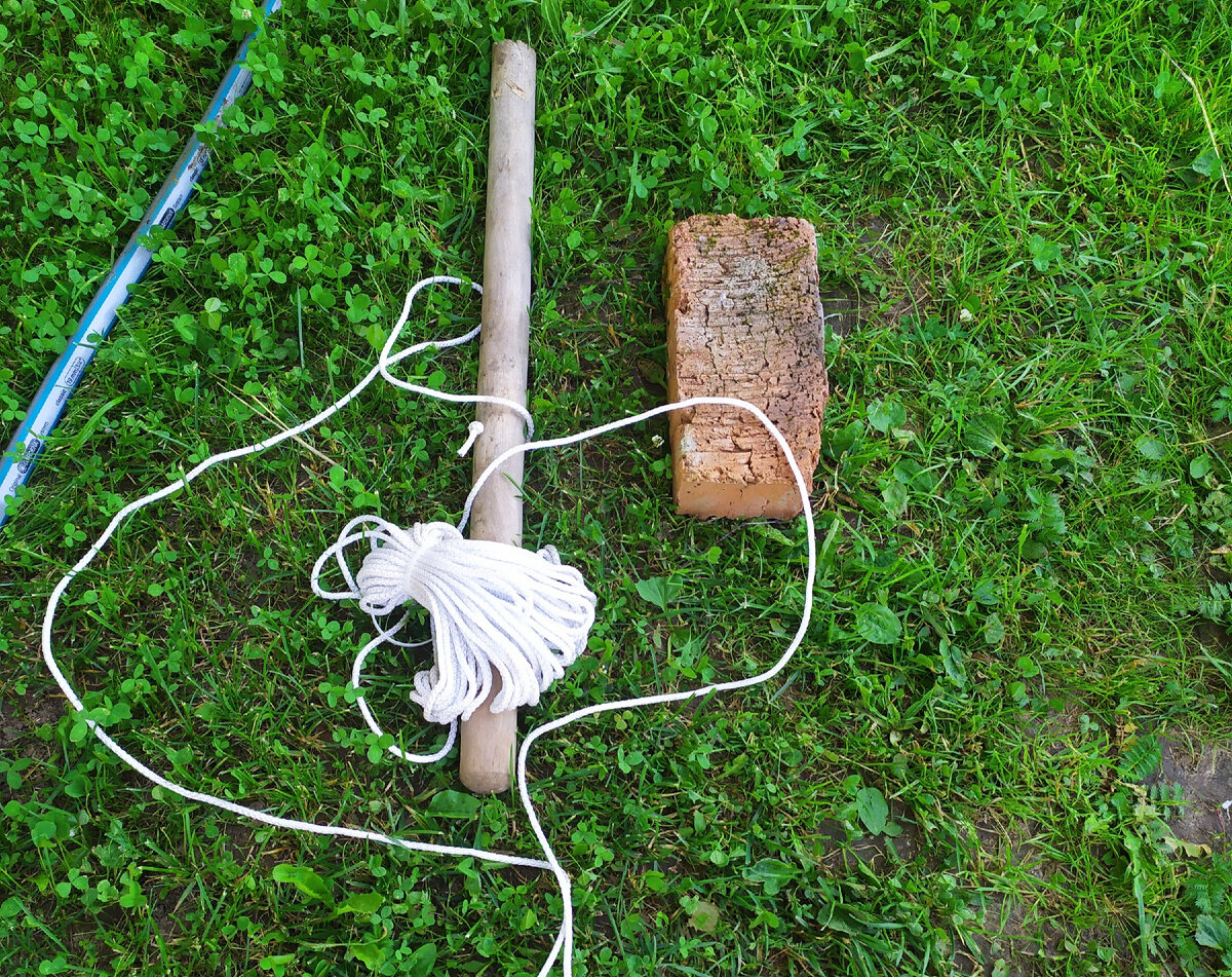 В черенке уже сделана дырка. Большим гвоздем. И завязан узелок. Кирпич чем хорош, что известно сколько весит - примерно 3 кг и его легко обвязать веревкой.