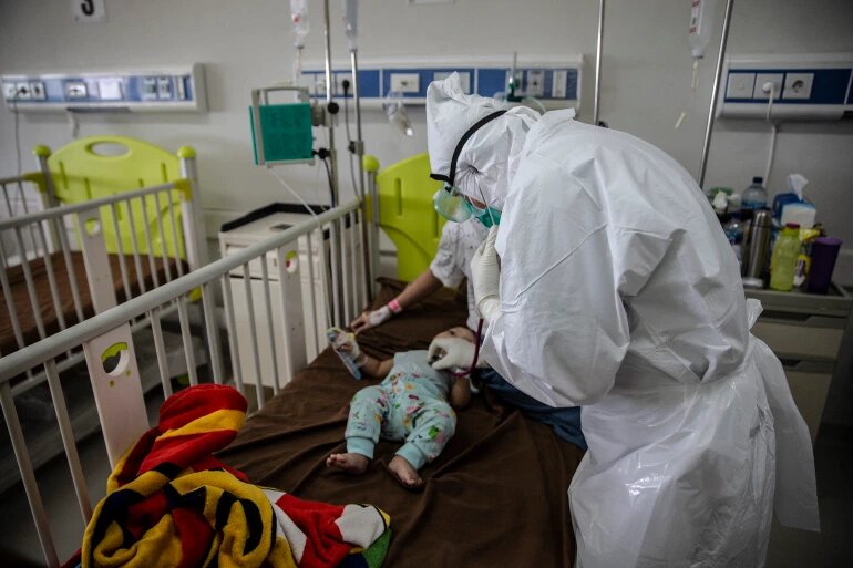 Врач осматривает ребенка с положительным результатом на коронавирус COVID-19 в больнице в Богоре в июне