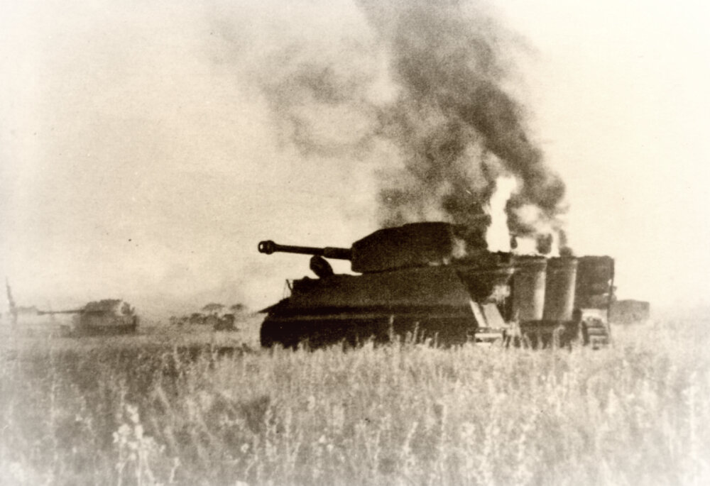 Горящий немецкий танк Pz.Kpfw. VI «Тигр» в поле во время операции «Цитадель». Июль 1943 г.