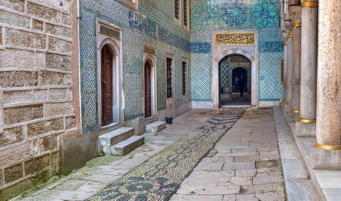 По этой выложенной гравием дорожке ехал султан на коне. А над арочным сводом виден аят из Корана.