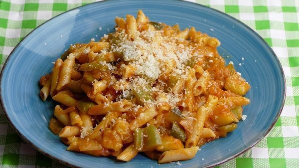 Некоторые макароны и овощи с тертым сыром готовы к подаче.