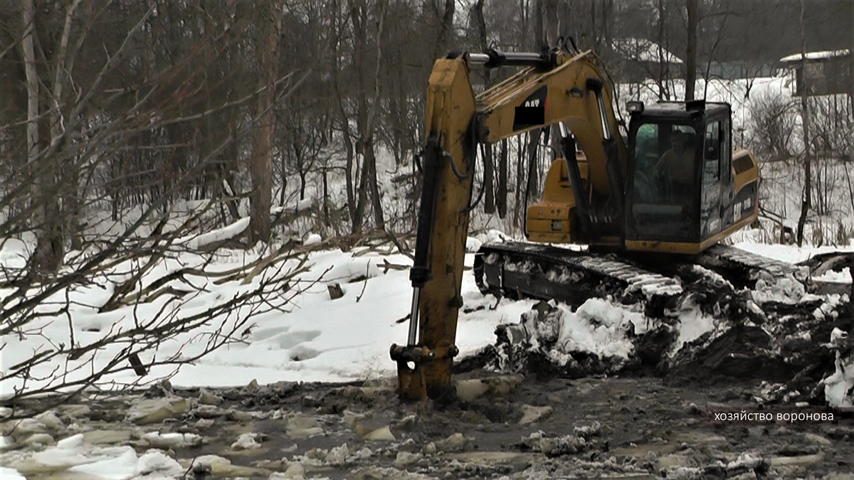 эксковато зимой копает в воду