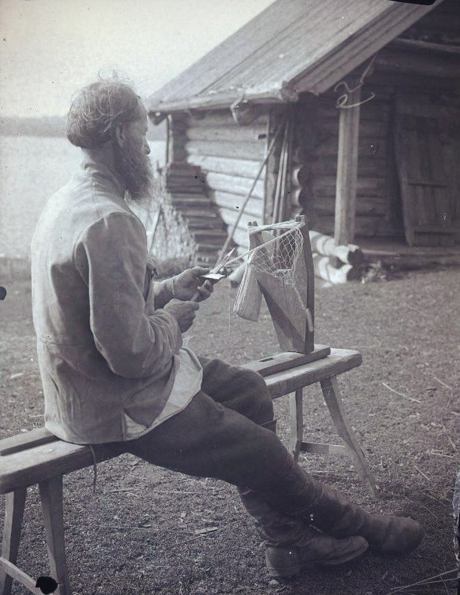 Тимофей Демьянович Костыков (59 лет) за плетением рыболовных сетей. Карелия, д. Яковлевка Лоянской волости. 1927. Карелы. Фото А.А. Беликова