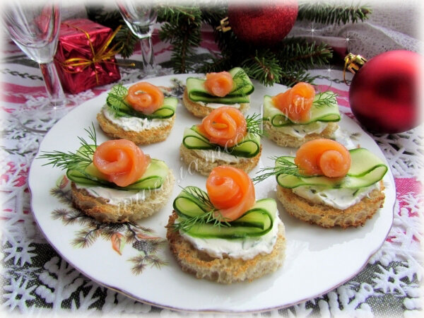 Творожный сыр соединяем с рубленной зеленью. Хлеб подсушиваем в духовке или тостере. Смазываем кусочки хлеба сыром. Украшаем огурцом и рыбой.