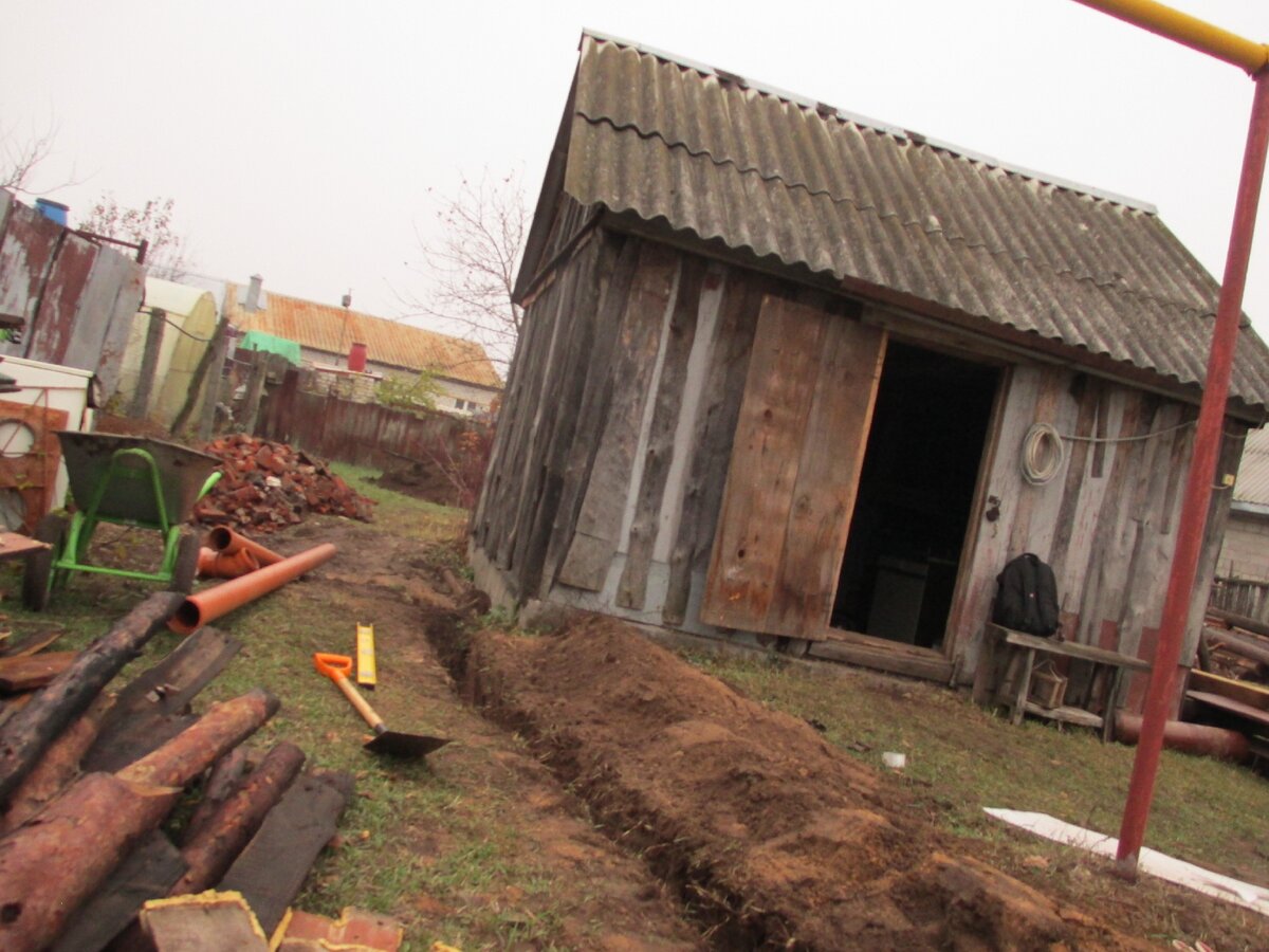 Пока позволяла погода я активно занялся земляными работами. Копал траншею и укладывал в нее трубу от дома к септику.