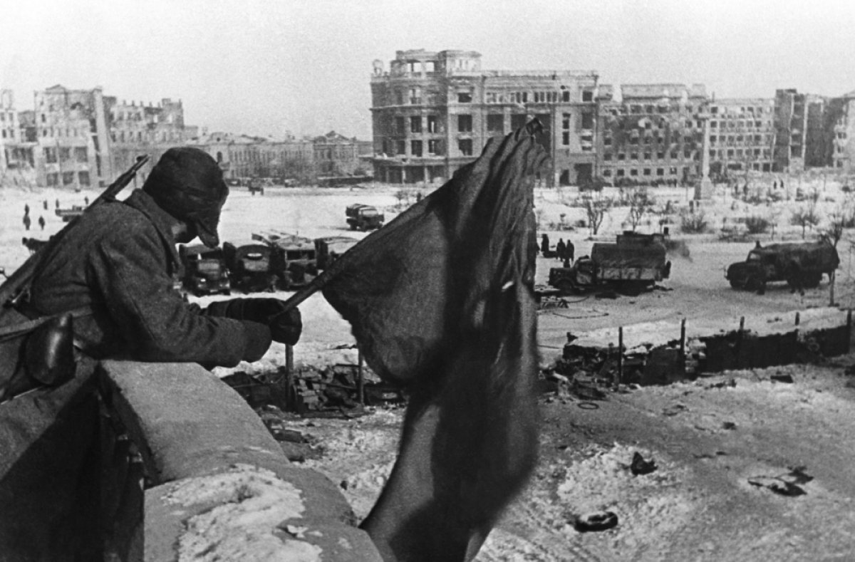    Сталинградская битва. Июль 1942 - февраль 1943 гг. Центральная площадь Сталинграда. Русский солдат держит флаг над освобожденным городом. 31.01.1943