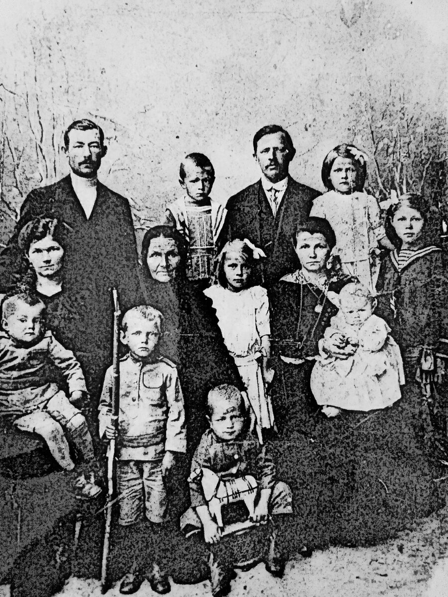 Слева на руках у матушки автор, рядом - брат  с ружьем, за ним бабушка, крайний слева - отец