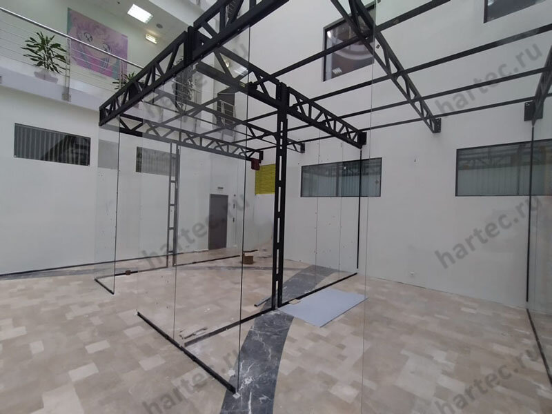 Офис установливается в атриумной зоне бизнес-центра, поэтому мы возводим металлокоркас, прозрачные стены, перегородки из стекла, потолок Грильято укладывается на направляющие. Здесь предусмотрена вся необходимая электропроводка, вентиляторы, освещение, интернет.