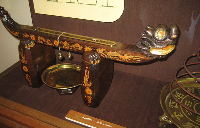 Старинный китайский будильник. Сверху лежит медленно тлеющая палочка. Когда жар добирается до нитки, та перегорает, грузик падает на медное блюдце, от звона которого спящий должен проснуться. Фото с ресурса https://kulturologia.ru