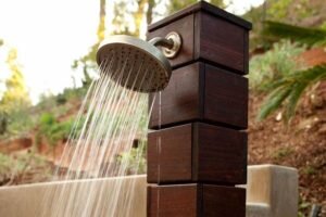 Находясь на даче в жару, хочется освежиться, особенно после работы на огороде, в саду. Но не у всех есть возможность обустроить на территории бассейн или баню. Хорошим выходом послужит создание временного или стационарного летнего душа, теплые струи которого быстро снимают усталость, освежают и успокаивают после тяжелого рабочего дня. Достоинством таких сооружений является возможность их возведения из доступных материалов, а также разнообразие конструкционных решений. В статье мы поговорим о том, как сделать летний душ на даче своими руками и какие тонкости в его оформлении существуют.