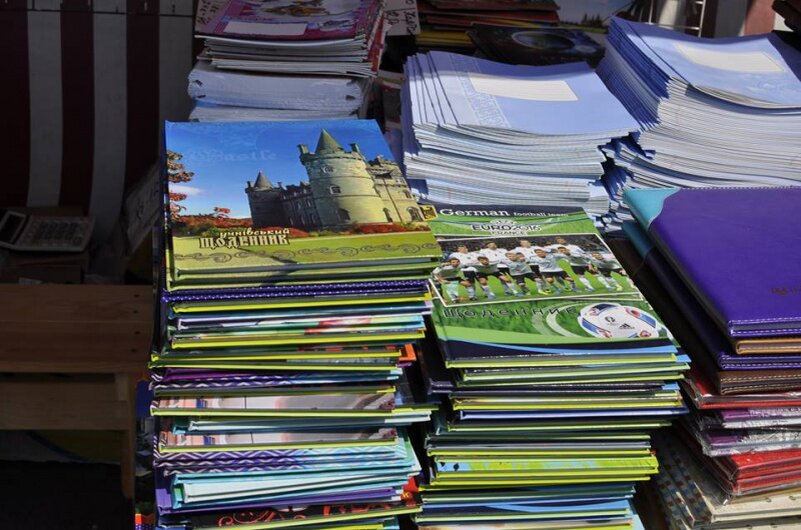 стопка школьных тетрадей. куча тетрадей. куча тетрадей на столе. стопка тетрадей. стопка книг.