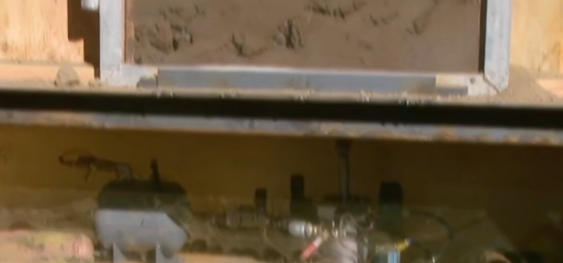 Робот наносит удары по крышке гроба, находящегося по землей