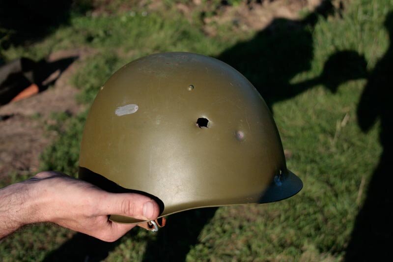 Спас от пули. Каска СШ-68 пробитие. Пулевое отверстие в каске. Военная каска на голове.