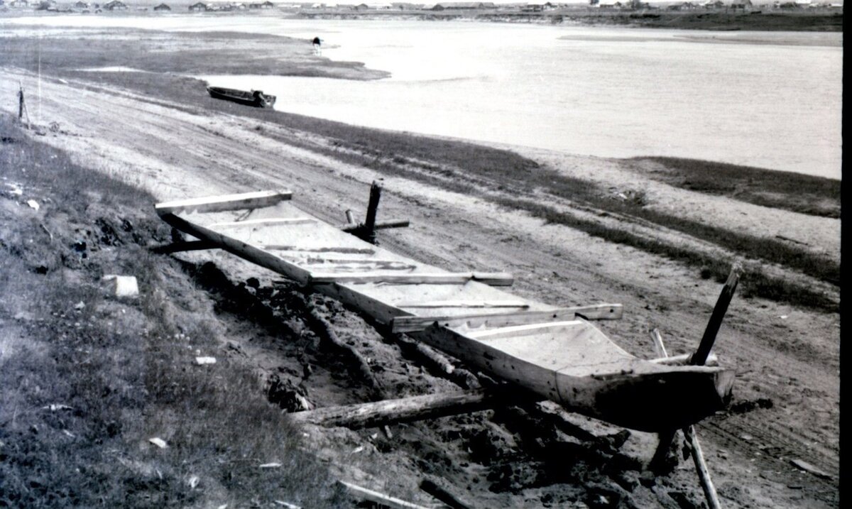 Фото 1971 г. нижнетоемского краеведа С.Г. Третьякова. Снято в Выйской деревне Новинки. Изготовление лодки-осиновки. На фотографии видны распорки, с помощью которых придавали лодке нужную форму. Под дном лодки разводили огонь, чтобы распарить древесину. 