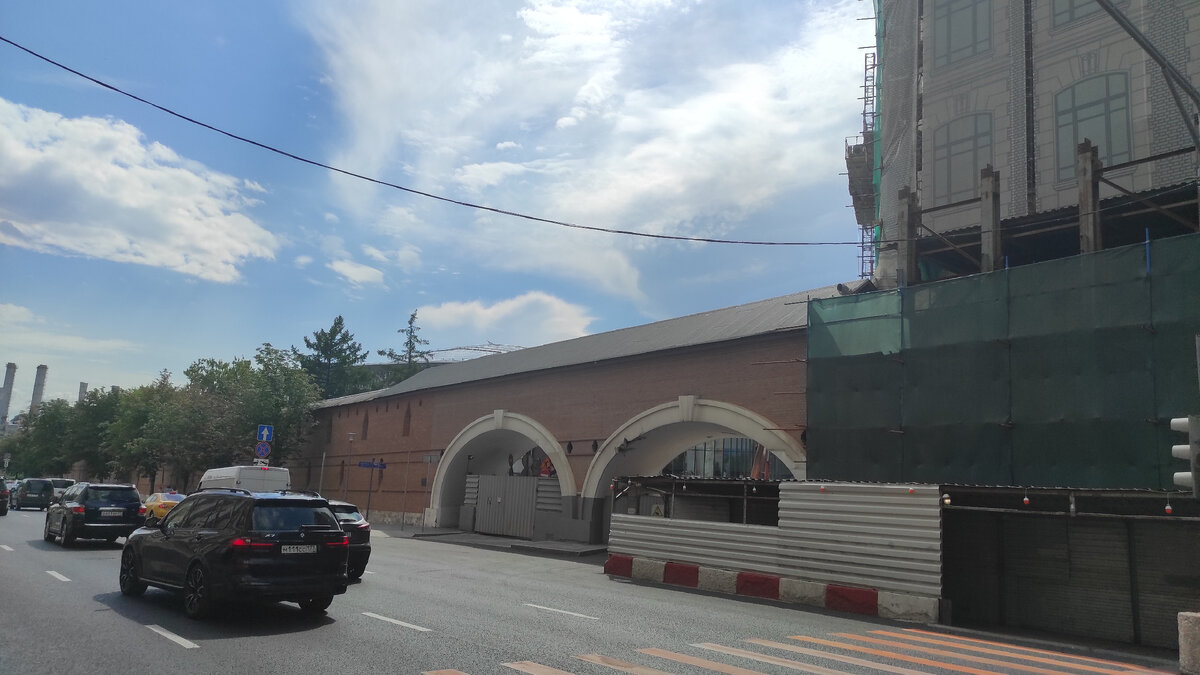 В продолжении стены идёт постройка современного здания