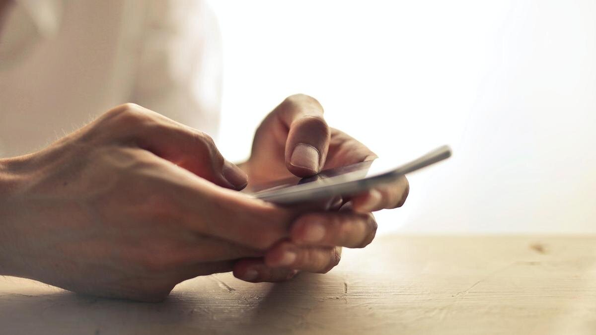    Парень держит в руках телефон:pexels.com