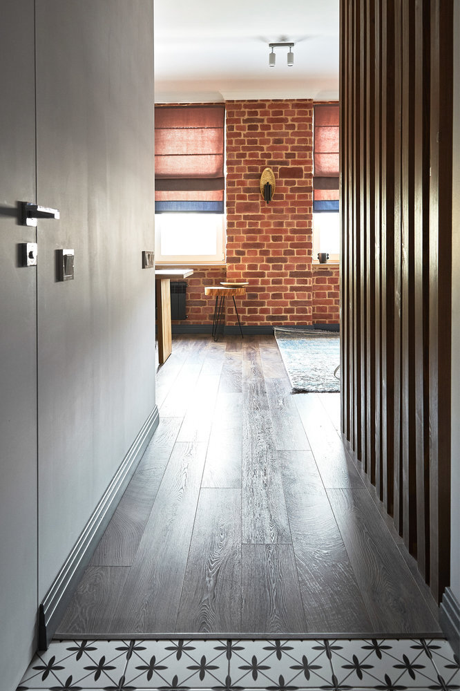 От тяжёлых драпировок отказались, окна завесили ролл-шторами. Тёмные плинтуса и радиаторы добавляют контраст.