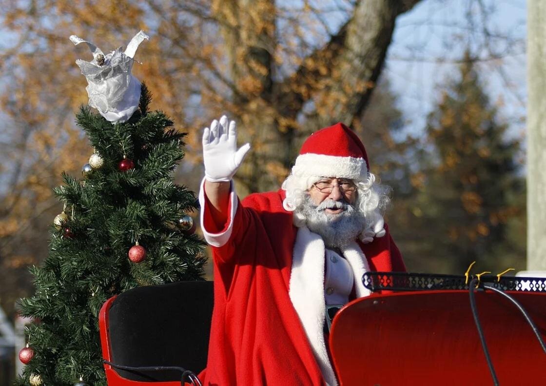    Санта-Клаус в санях по улице машет рукой:Pixabay