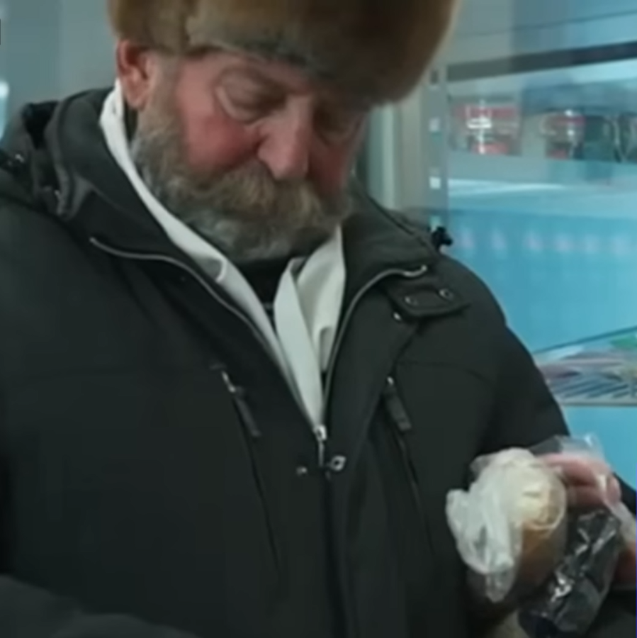 Дед берет сосиски, пересчитывает мелочь и кладет пачку сосисок обратно в холодильник. Кадр из того самого ролика.