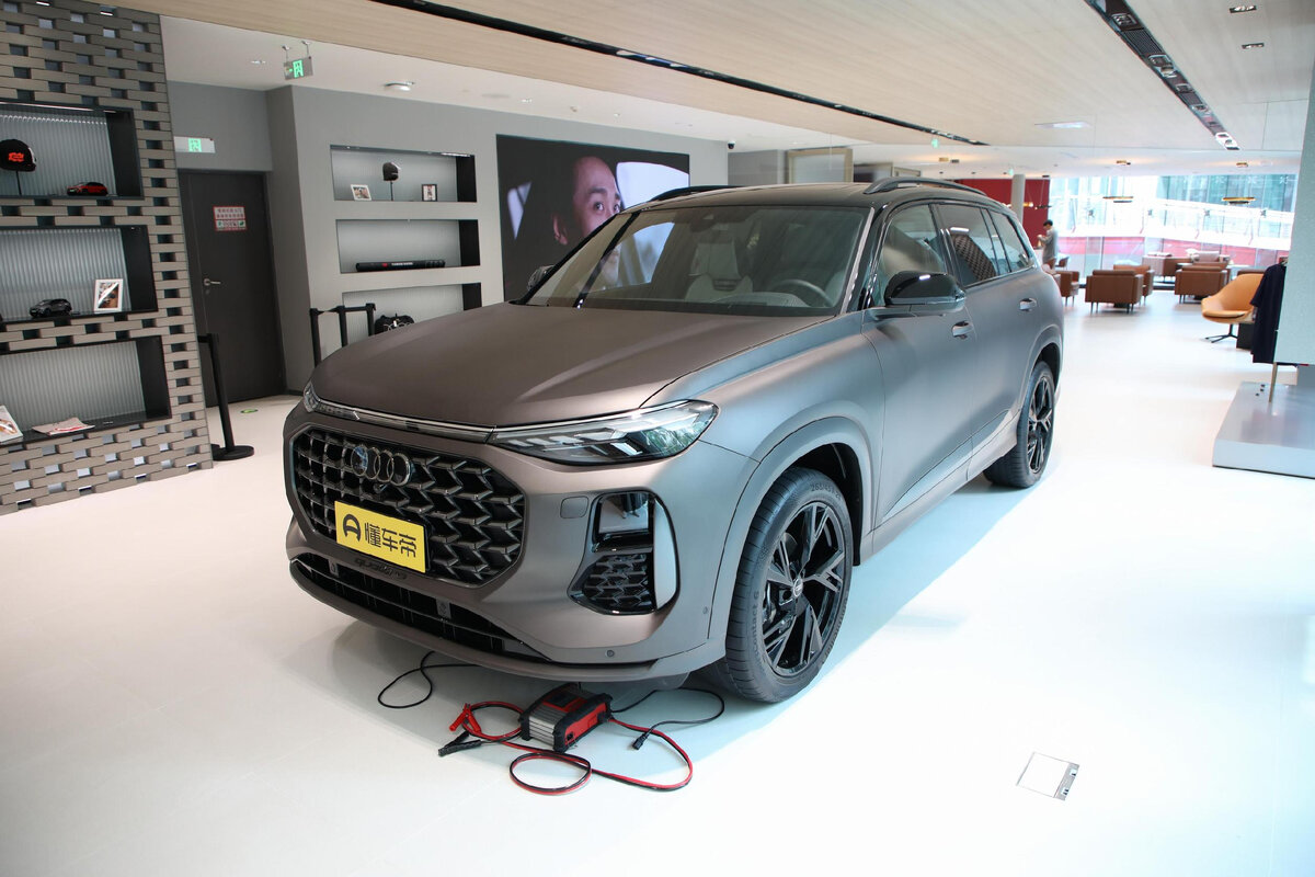 Cамый крупный серийный автомобиль немецкой марки Ауди Q6 Стоимость от 6 800 000
В зависимости от комплектации новая модель Ауди Ку 6 может иметь колеса диаметром от 19 до 21 дюймов. Плюс для нее доступен пакет Sport, для которого характерно наличие другой решетки радиатора и черного наружного декора вместо хромированного. Салон такого кроссовера уже в базе трехрядный, причем у начальных версий он семиместный со стандартным диваном на втором ряду и трехзонным климат-контролем.
Более дорогие версии имеют шесть посадочных мест: на втором ряду у них установлены раздельные кресла с подогревом, вентиляцией, вибромассажем и электроприводом, хотя и не таким продвинутым, как спереди. Сам дизайн интерьера нового Audi Q6 решен в современном для немецкой марки стиле. Передняя панель здесь имеет «деревянные» акценты, причем на ней расположено сразу три дисплея.
Среди них 12,3-дюймовая цифровая приборка, центральный 10,1-дюймовый тачскрин мультимедийной системы и расположенный сразу под ним вспомогательный 8,6-дюймовый экран, с которого осуществляется управление климат-контролем и подогревами. Плюс нельзя не отметить наличие в машине характерного селектора КПП. Что касается интерьера отделки, то немцы преимущественно использовали натуральную кожу.
Ауди Q6 в новом кузове достигает в длину 5 099 мм (+ 36 по сравнению с Q7), в ширину — 2 014 (+ 44), в высоту — 1 784 (+ 43). Колесная база составляет 2 980 миллиметров.