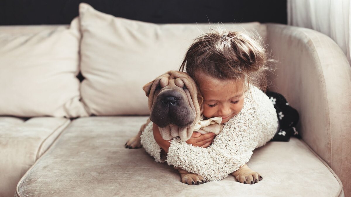 Девочка обнимает собаку 