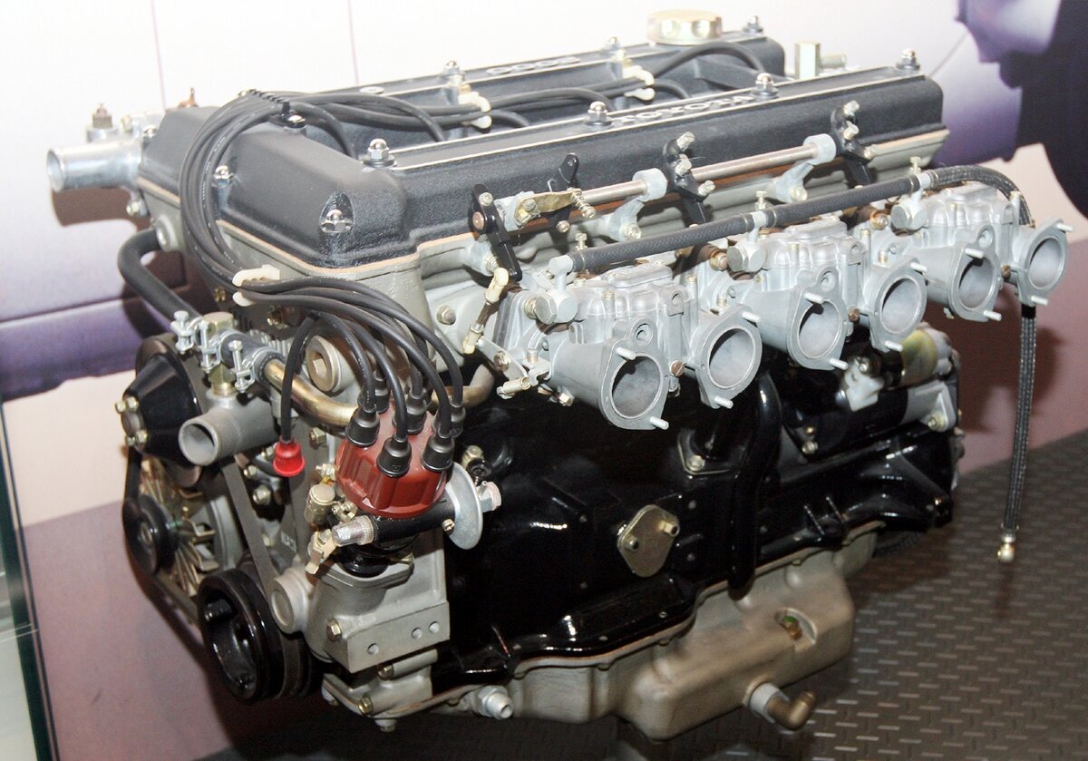 Системы EFI ещё нет, поэтому мотор на сдвоенных горизонтальных карбюраторах. 2 литра, 6 цилиндров в ряд, 2 вала. Мощность даже на карбах была около 150 л.с.