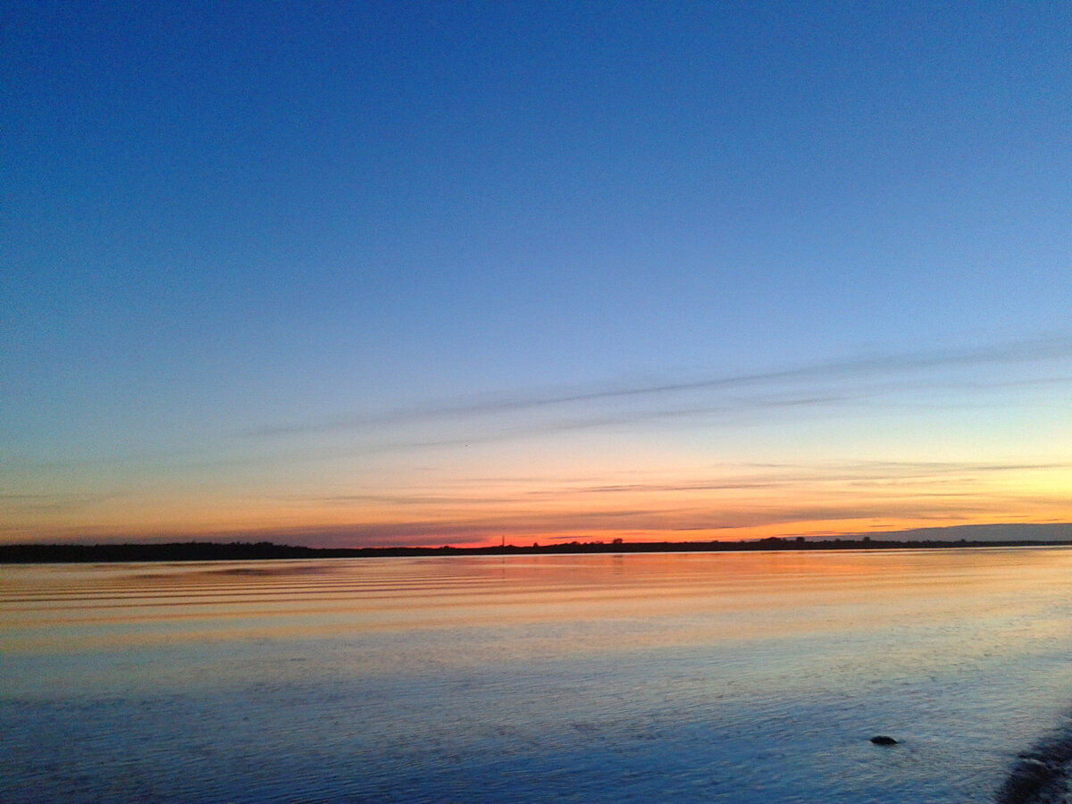...темнеют заросли по берегам, сумрак плотнее обступает жёлтый языкастый  костёр, высоко над макушками деревьев белеет вечернее небо, и отливают  оранжевым светом далёкие Тёплые Бугры на востоке — туда ещё падают  зоревые лучи закатного солнышка.