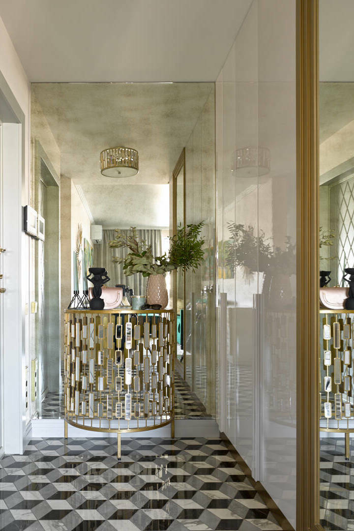 В этом проекте сочетали большую золотистую консоль и зеркало с эффектом состаренности во всю стену. Дизайнер Елена Маркина﻿, проект квартиры с гаражом для бытовой техники и живописным триптихом