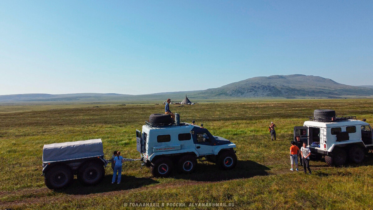 Наша команда Медиаразведки Туту. Справа видно, как к нам подошёл незнакомый человек и фотографирует машины. Вдали - чум, который вышли фотографировать мы. Фото: из личного архива
